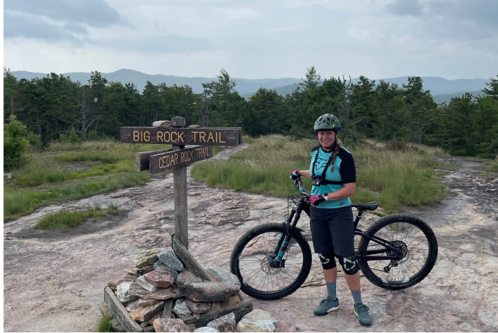 Amy in the mountains with her bicycle