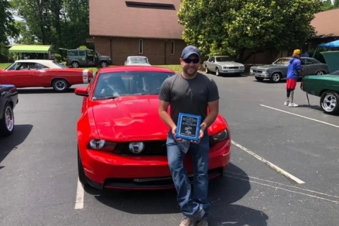 Jeff in front of a red car