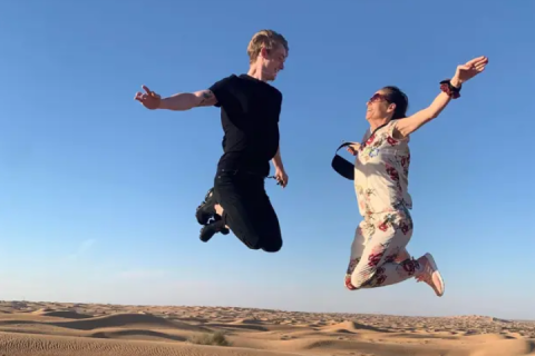 Maria and her son outdoors jumping in the air