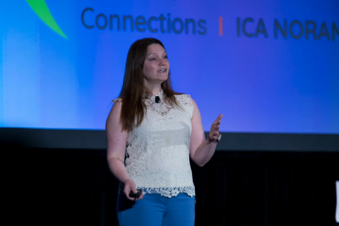 Nicole presenting on stage at a Quadient event