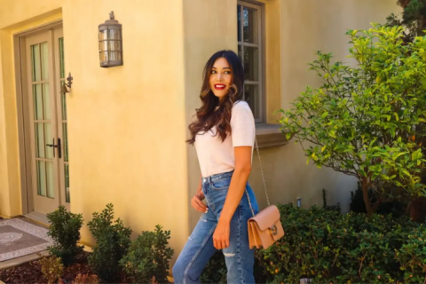 Rocio posing in front of a yellow building and a tree